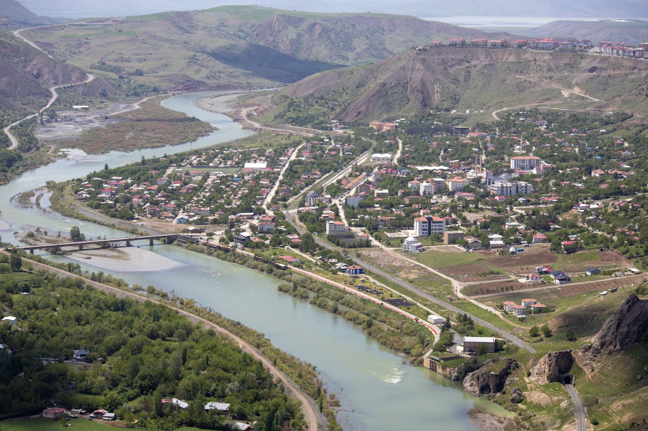 services-01 Scenic aerial view of Palu, Elazığ, Türkiye, showcasing a winding river and lush landscape.